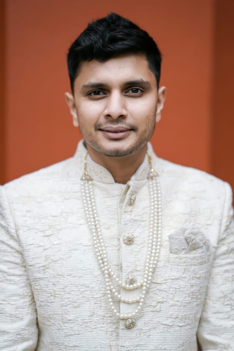 Portrait of a groom wearing a cream sherwani and pearl necklace, captured by Aceoclock wedding photography company in Kerala