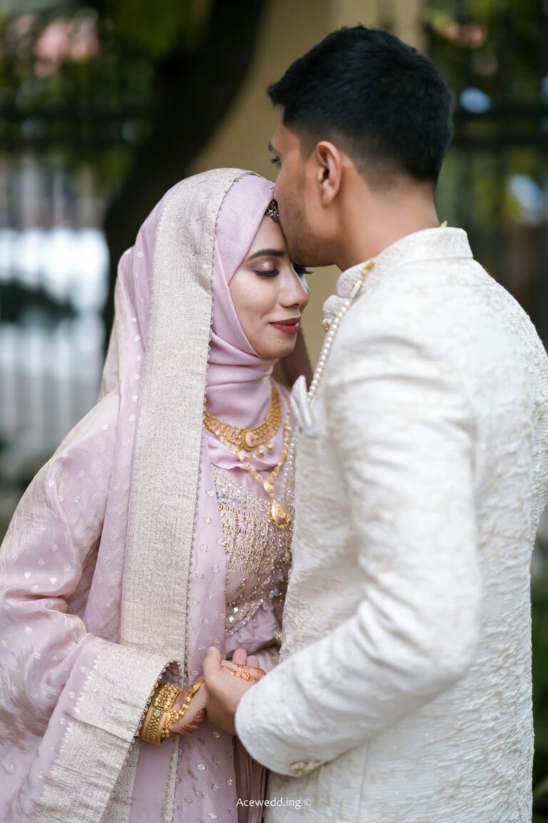 Emotional moment of a Muslim wedding couple, with the groom kissing the bride’s forehead, captured by Aceoclock wedding photography company in Kerala